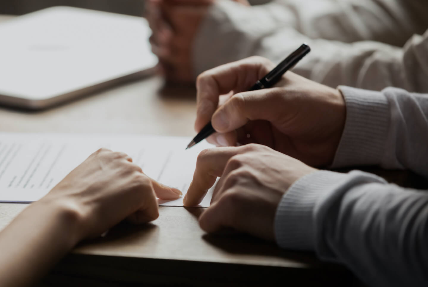 Close up of hands signing a document