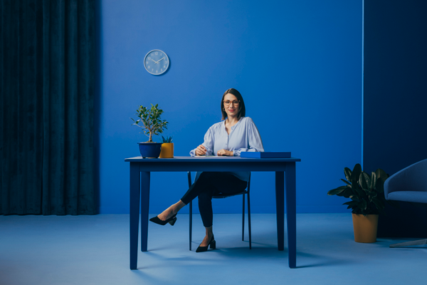 Woman sitting behind desk.