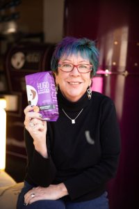 Hugo Coffee owner smiling while holding a bag of Hugo Coffee