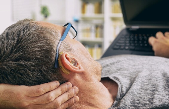 Man laying down at home while working on laptop