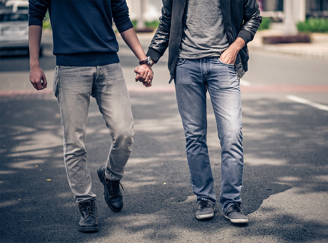 Men holding hands walking down the street